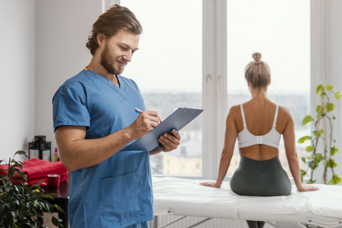 male-osteopathic-therapist-with-clipboard-female-patient-office