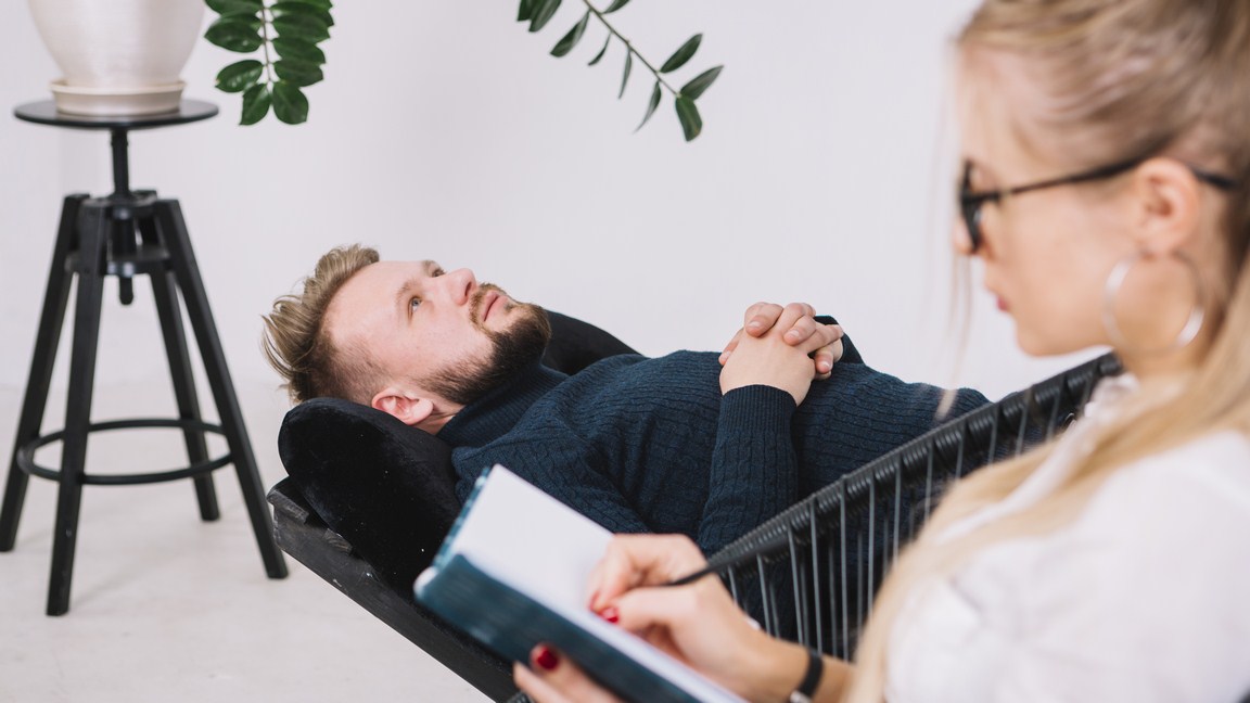 close-up-female-psychologist-writing-down-notes-during-therapy-with-her-male-patient